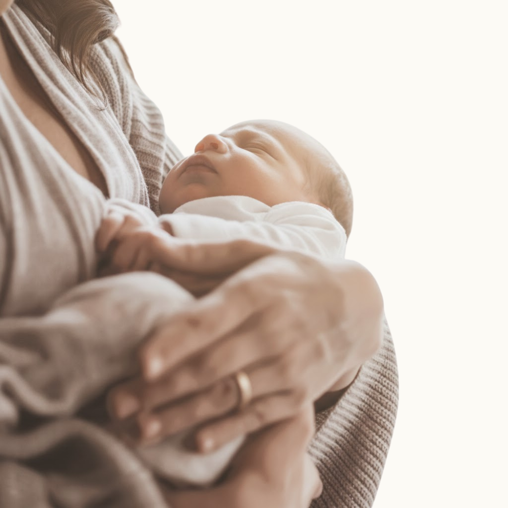 A woman gently cradles a baby in her arms, showcasing a tender moment of care and affection.