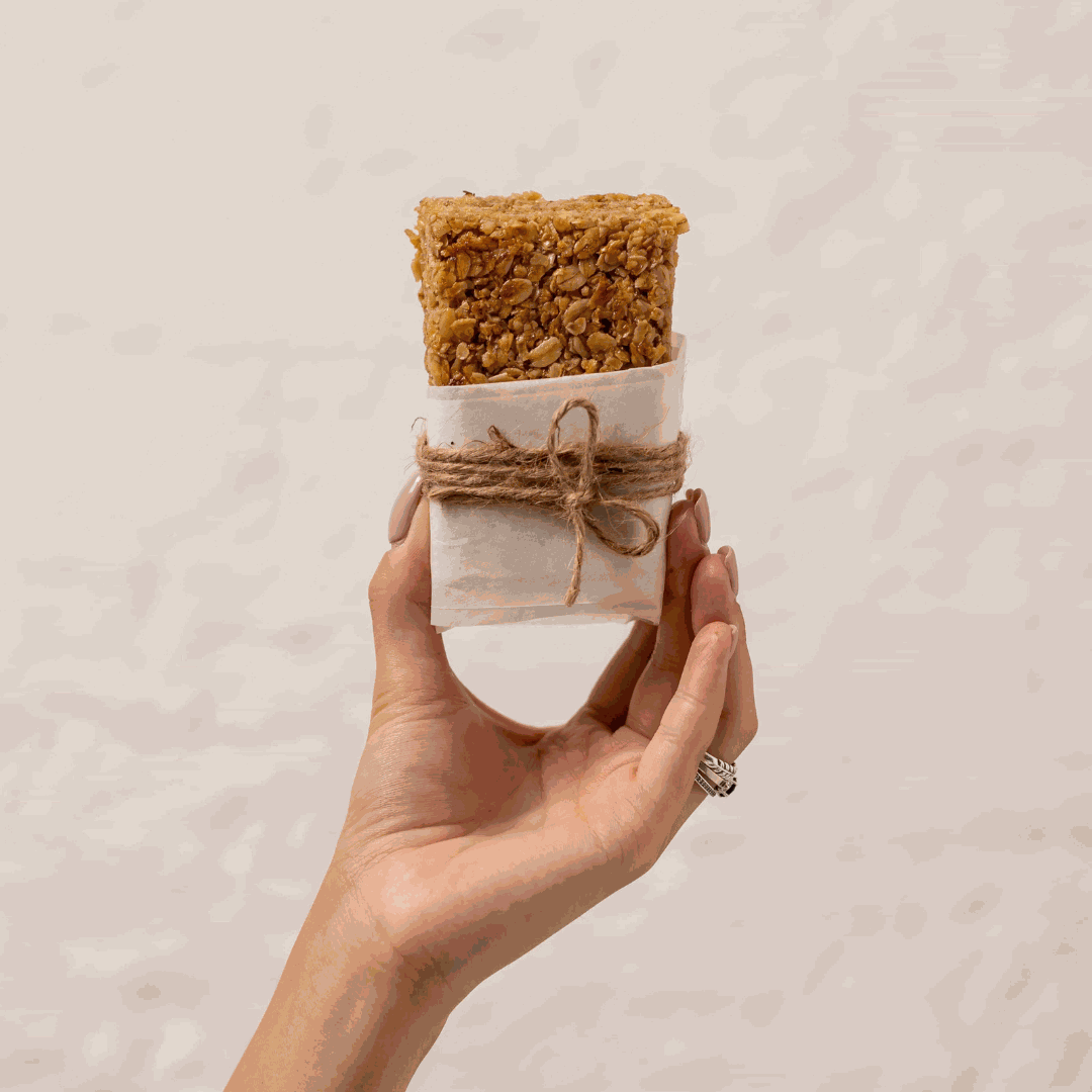 A hand grips a piece of bread, suggesting preparation for a delicious bite.