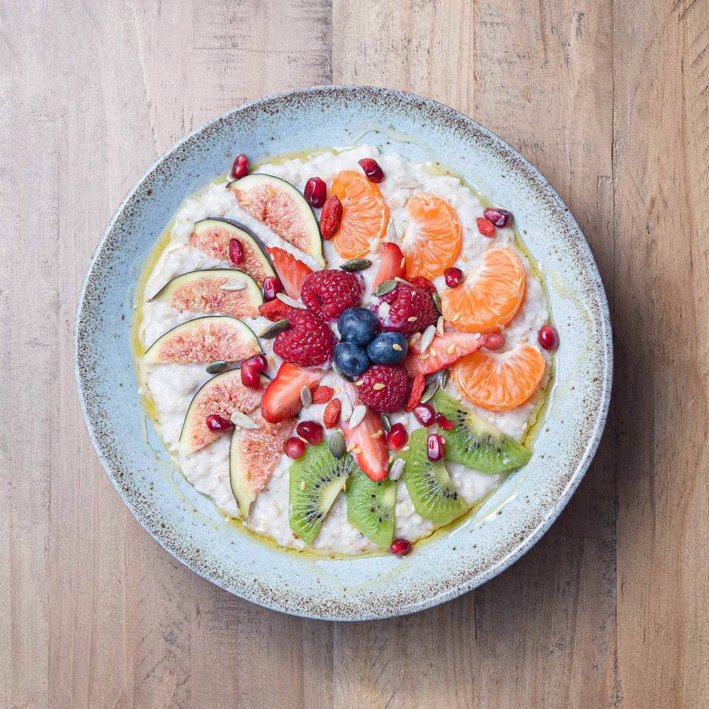  A bowl of oatmeal topped with fresh fruit and nuts, showcasing a healthy and colorful breakfast option.