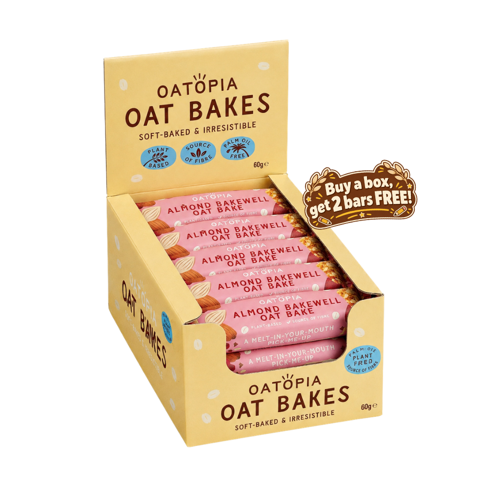 Oatòpia Oat Bakes almond bakewell oat bake in a yellow display box with pink wrapped bars inside, plus a brown promotional badge that says buy a box, get 2 bars free.