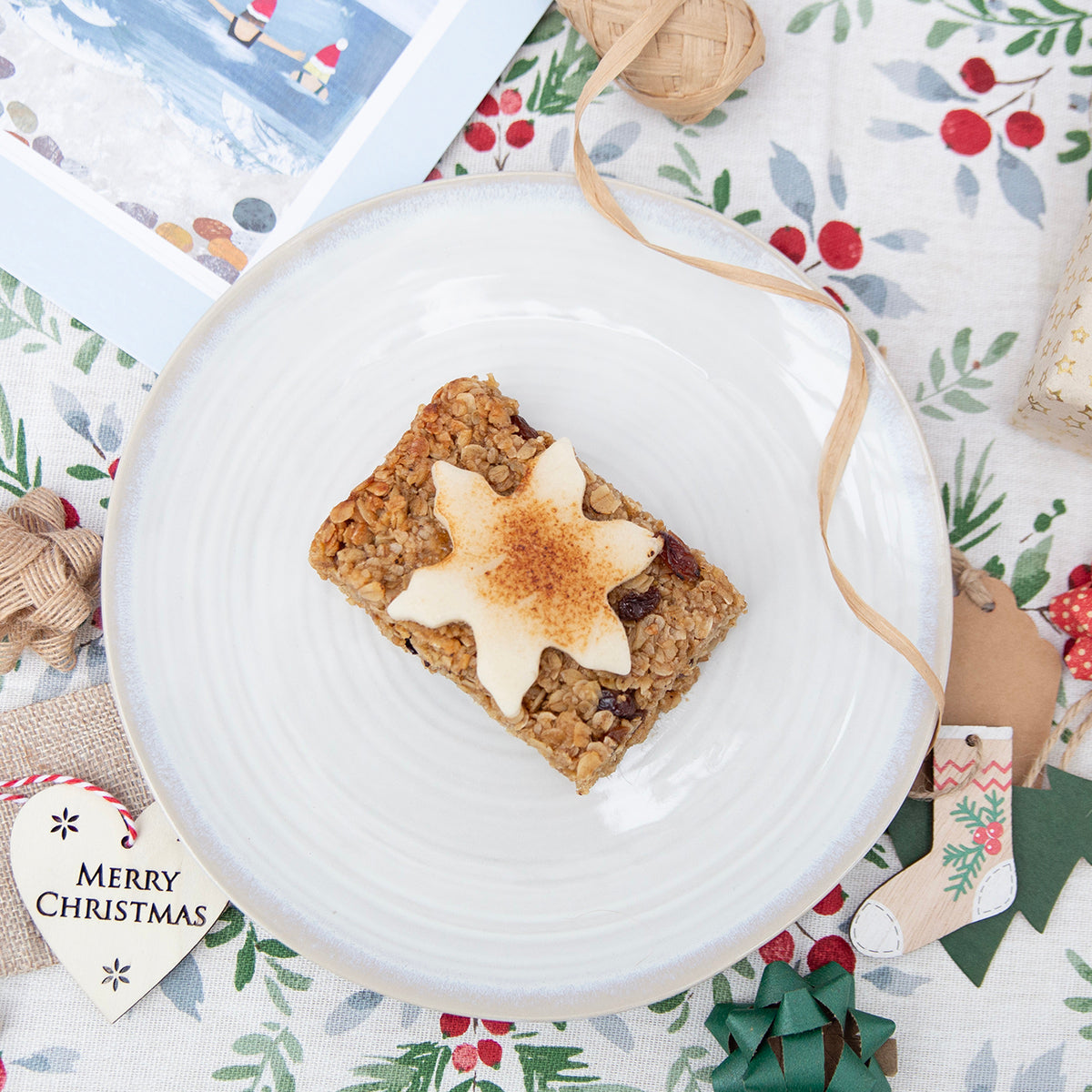 A slice of Christmas flapjack on a white plate, featuring a fruity base and a thick marzipan layer, perfect for the season.