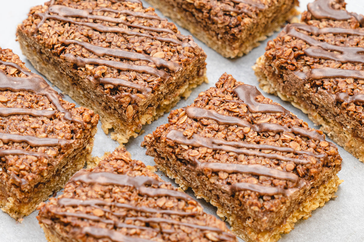 Chocolate flapjack-covered cereal bars on a white surface