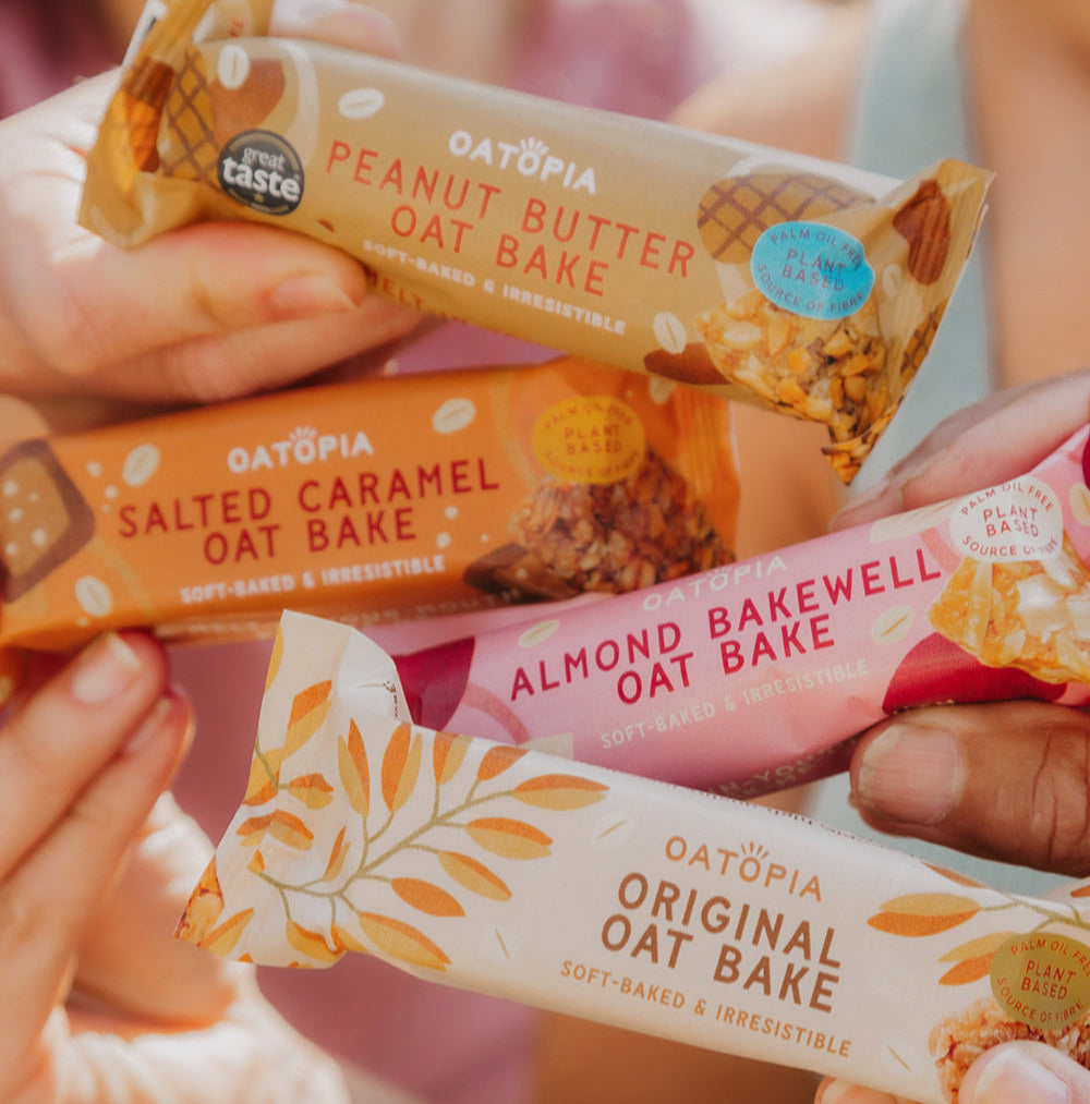 Four Oatopia baked oatmeal bars in different flavors held by hands.