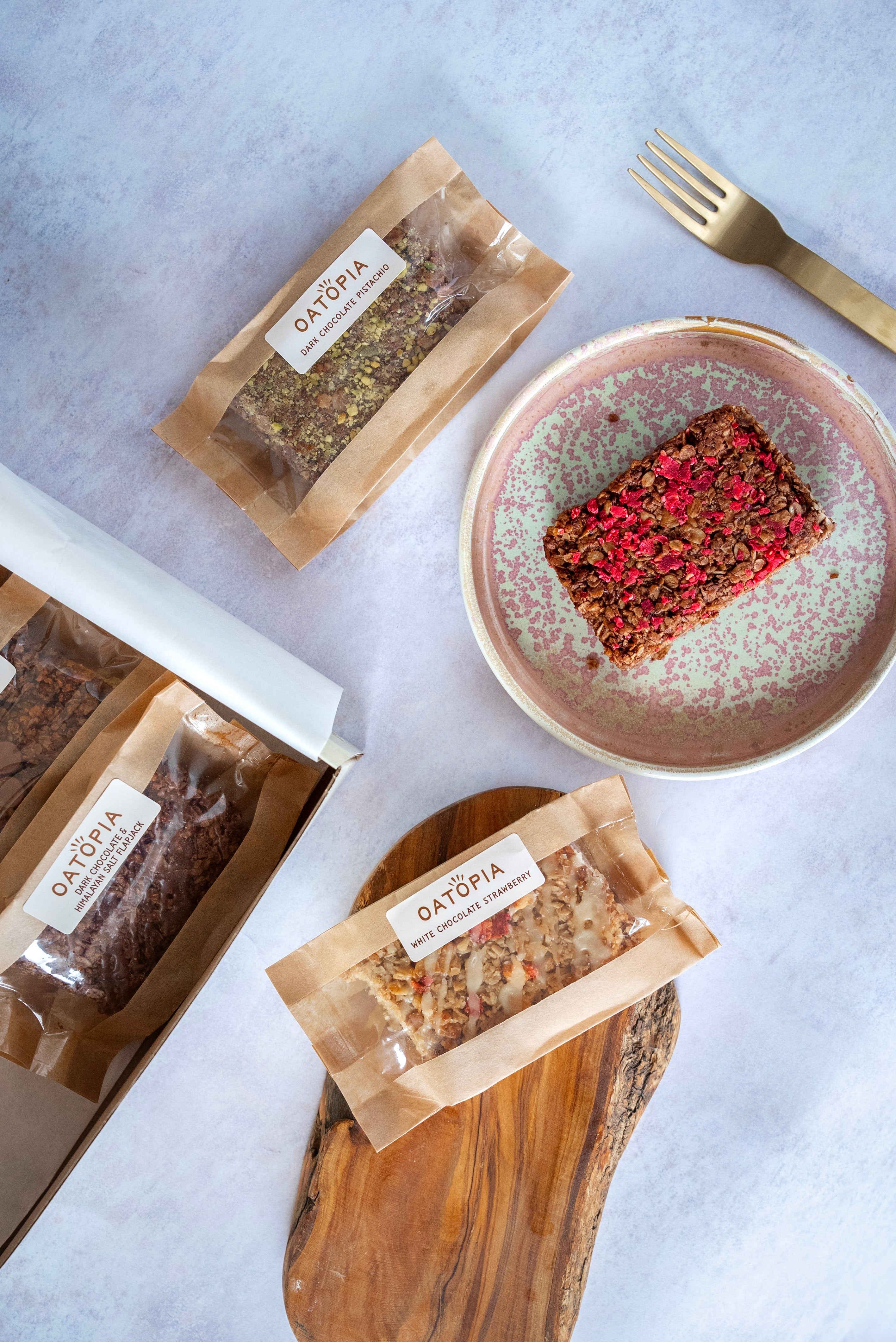 A plate displaying a slice of chocolate oat cake and snacks, representing a delightful selection of handmade treats. Oatopia Chocolate_Box 
