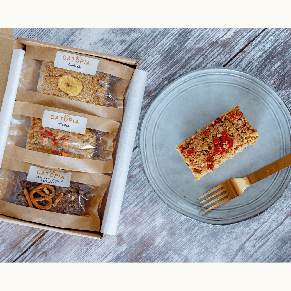 A vibrant box of soft baked flapjacks with a fork and knife, highlighting the tasty summer flavors inside.