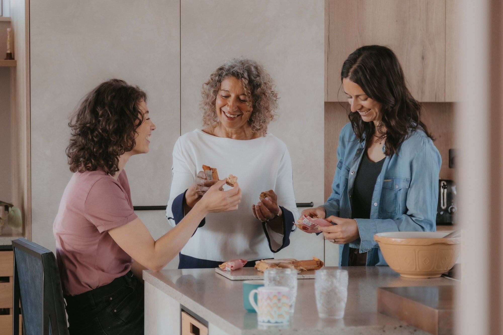 Three women in a kitchen preparing food together.