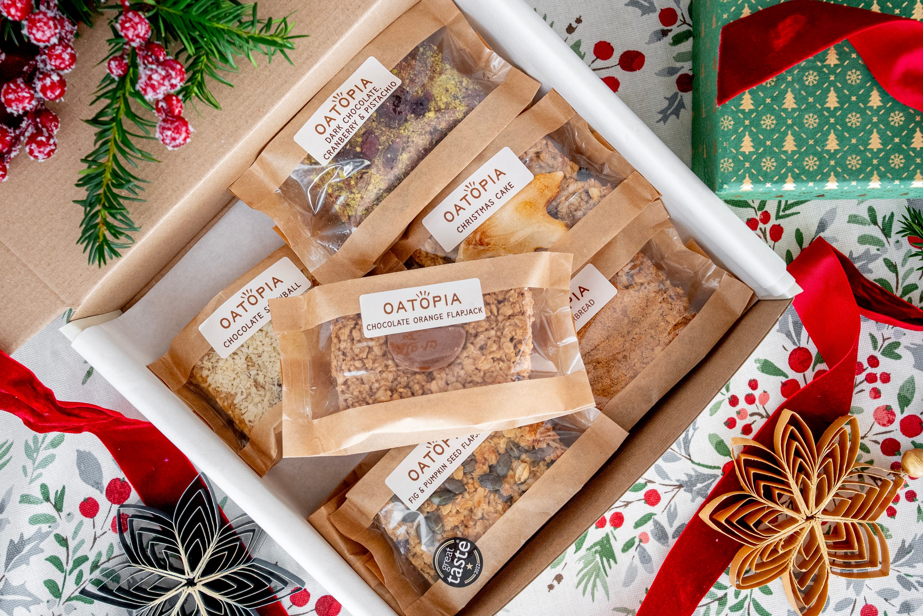 Box of Oatopia flapjacks with Christmas-themed wrapping paper in the background