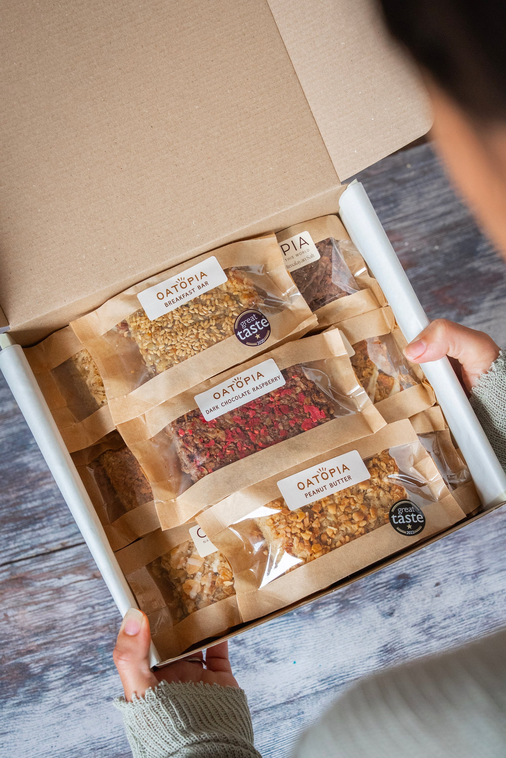 Box of Oatopia products on a wooden surface