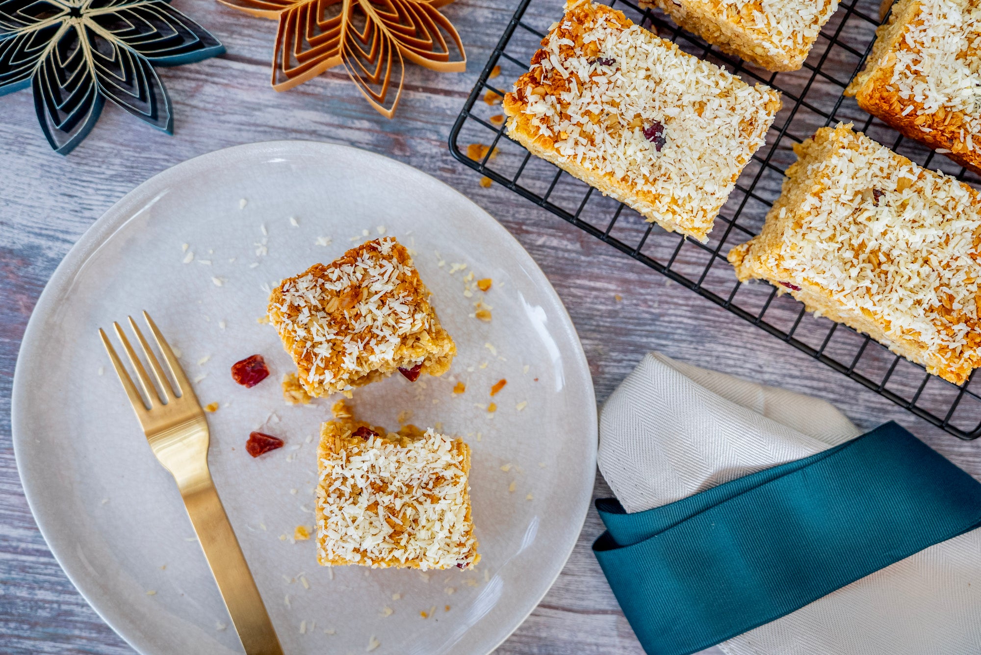 Square dessert bars on a plate with a cooling rack in the background