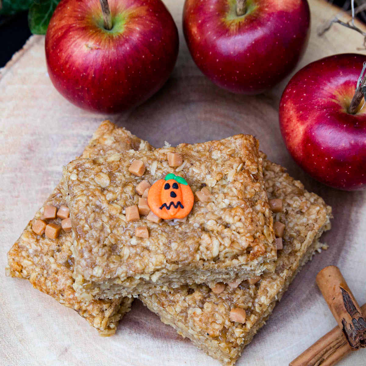  A delicious pile of oatmeal bars, each adorned with a cute pumpkin decoration, perfect for fall snacking.